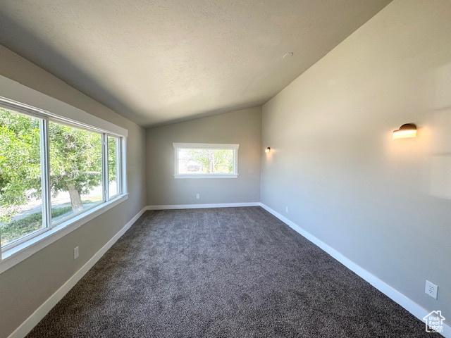 933 E 1150 N, Ogden, UT 84404 - unfurnished room with vaulted ceiling, baseboards, and dark carpet
