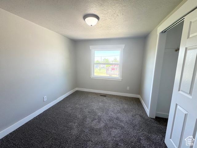 933 E 1150 N, Ogden, UT 84404 - unfurnished room with a textured ceiling, dark colored carpet, and baseboards