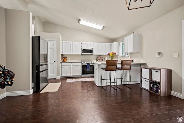 679 W 3600 S, Riverdale, UT 84405 - kitchen with appliances with stainless steel finishes, vaulted ceiling, a breakfast bar area, white cabinets, and a peninsula