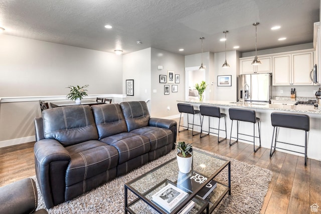 1722 W Naxos Ln, South Jordan, UT 84095 - living room featuring dark wood-style flooring, recessed lighting, a textured ceiling, and baseboards