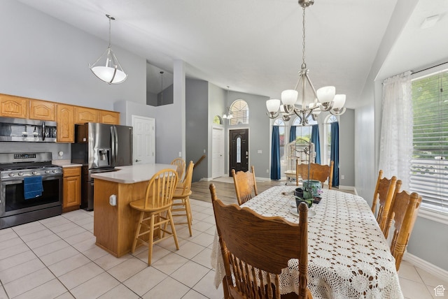 192 Starboard Ln, Stansbury Park, UT 84074 - dining space featuring a chandelier, baseboards, light tile patterned floors, and high vaulted ceiling