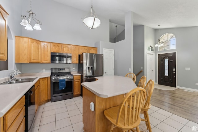 192 Starboard Ln, Stansbury Park, UT 84074 - kitchen featuring appliances with stainless steel finishes, high vaulted ceiling, light tile patterned floors, a chandelier, and a sink