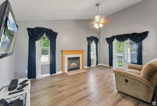 192 Starboard Ln, Stansbury Park, UT 84074 - living area with vaulted ceiling, ceiling fan, a tile fireplace, wood finished floors, and baseboards