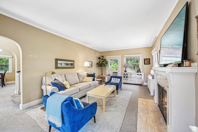 114 N Virginia St, Salt Lake City, UT 84103 - living room with baseboards, light colored carpet, arched walkways, and a lit fireplace