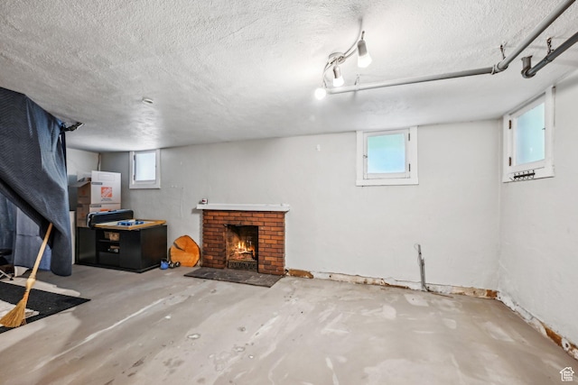 114 N Virginia St, Salt Lake City, UT 84103 - below grade area featuring a textured ceiling, a brick fireplace, and healthy amount of natural light