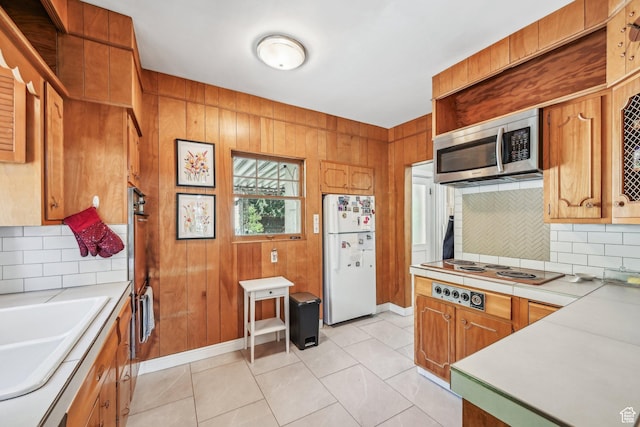 114 N Virginia St, Salt Lake City, UT 84103 - kitchen with freestanding refrigerator, stainless steel microwave, electric stovetop, decorative backsplash, and light countertops