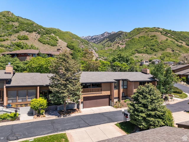 4968 S Partridge Way E, Ogden, UT 84403 - view of front of home with a mountain view, concrete driveway, a garage, a shingled roof, and a balcony
