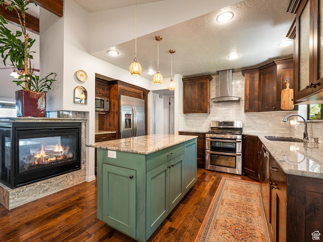 4968 S Partridge Way E, Ogden, UT 84403 - kitchen with wall chimney range hood, stainless steel appliances, green cabinets, a sink, and backsplash