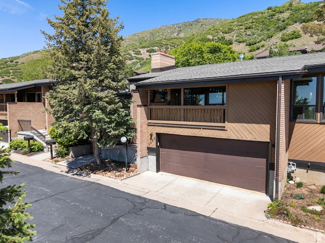 4968 S Partridge Way E, Ogden, UT 84403 - view of front facade featuring a mountain view, a garage, driveway, a chimney, and a shingled roof