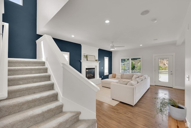 7859 N Sagebrush Ln, Eagle Mountain, UT 84005 - living area with ceiling fan, stairs, a glass covered fireplace, wood finished floors, and recessed lighting