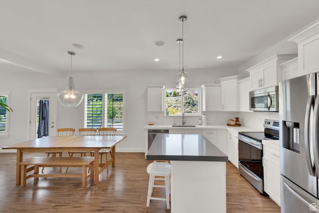 7859 N Sagebrush Ln, Eagle Mountain, UT 84005 - kitchen featuring appliances with stainless steel finishes, a sink, tasteful backsplash, light wood-style flooring, and plenty of natural light