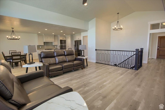 4016 W 625 S, West Point, UT 84015 - living room featuring a chandelier, light wood-type flooring, vaulted ceiling, and baseboards