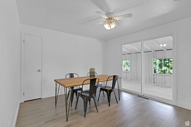 6975 N 2650 W, Honeyville, UT 84314 - dining room with wood finished floors, a ceiling fan, and baseboards