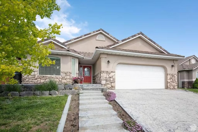 1096 S Bentley Blvd, Cedar City, UT 84720 - view of front of property with stucco siding, stone siding, an attached garage, and driveway
