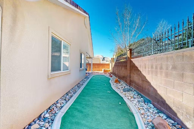 1096 S Bentley Blvd, Cedar City, UT 84720 - view of side of property featuring stucco siding, a fenced backyard, and a putting area