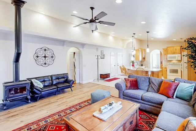 1096 S Bentley Blvd, Cedar City, UT 84720 - living area with arched walkways, a wood stove, ceiling fan, light wood finished floors, and recessed lighting
