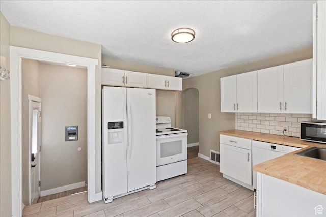 917 E Sullivan Rd, Ogden, UT 84403 - kitchen featuring white appliances, arched walkways, baseboards, and white cabinets