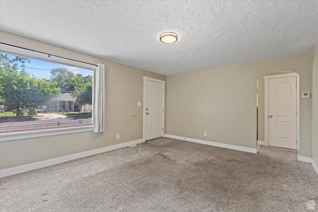917 E Sullivan Rd, Ogden, UT 84403 - spare room featuring arched walkways, carpet floors, a textured ceiling, and baseboards