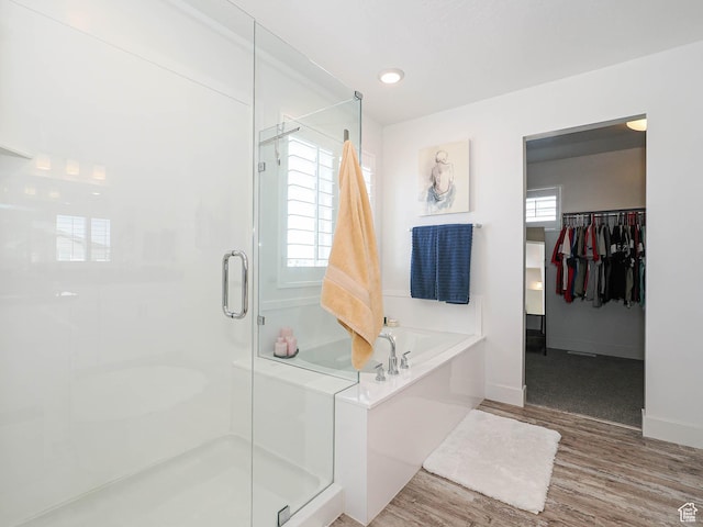 3022 S Shoreline Dr W, Syracuse, UT 84075 - full bathroom featuring a shower stall, a garden tub, a spacious closet, wood finished floors, and baseboards