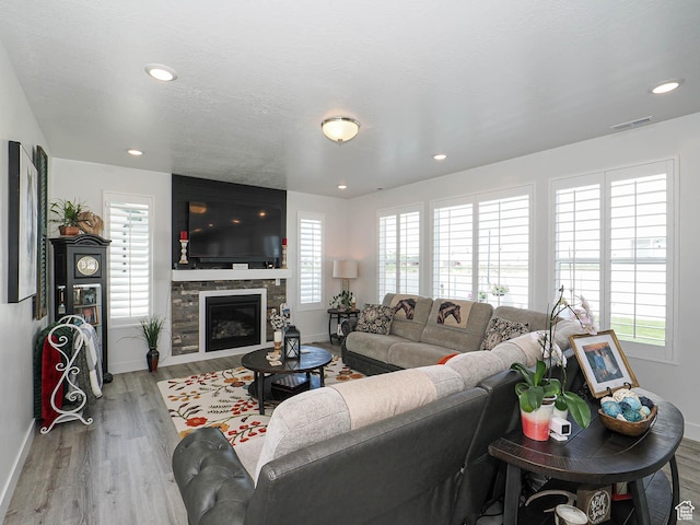 3022 S Shoreline Dr W, Syracuse, UT 84075 - living area with baseboards, wood finished floors, a glass covered fireplace, and recessed lighting