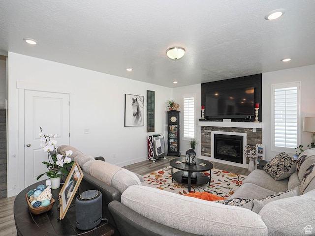 3022 S Shoreline Dr W, Syracuse, UT 84075 - living area featuring wood finished floors, a stone fireplace, baseboards, and recessed lighting