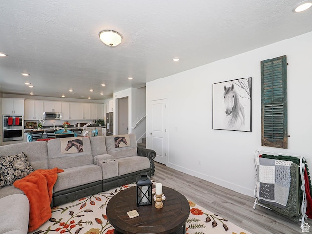 3022 S Shoreline Dr W, Syracuse, UT 84075 - living room featuring light wood-style floors, recessed lighting, stairs, and baseboards