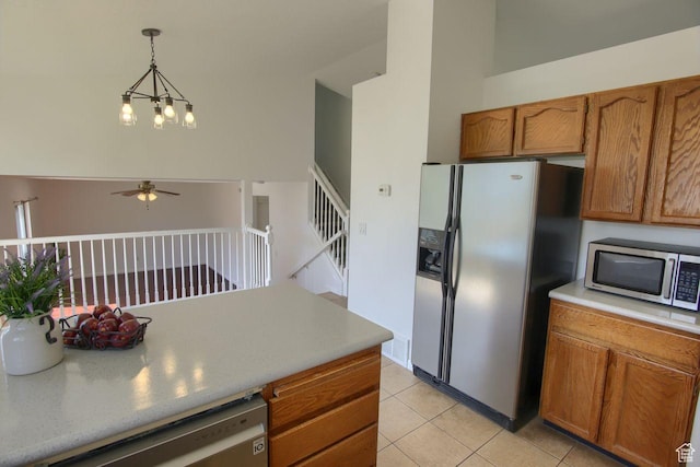 8183 S 2420 W, West Jordan, UT 84088 - kitchen with stainless steel appliances, a ceiling fan, brown cabinets, and light tile patterned flooring