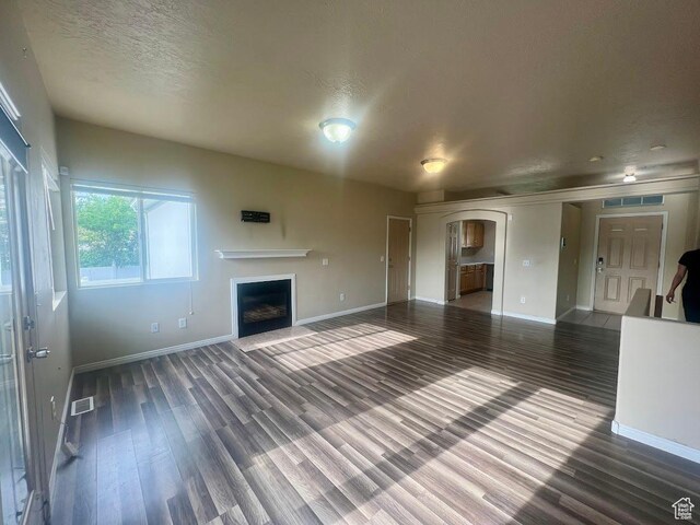 1913 N 370 W, Tooele, UT 84074 - unfurnished living room with baseboards, wood finished floors, a fireplace, and a textured ceiling