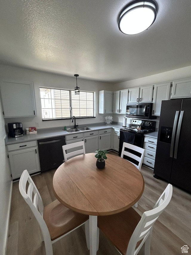 1350 W 150 N Unit 22, Vernal, UT 84078 - kitchen featuring black appliances, a sink, light wood finished floors, light countertops, and a textured ceiling