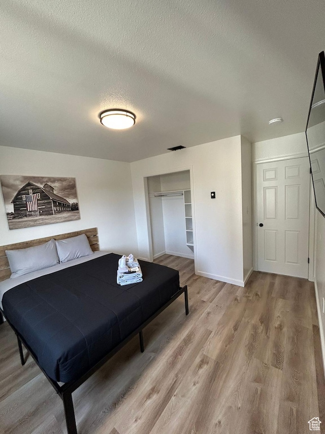 1350 W 150 N Unit 22, Vernal, UT 84078 - bedroom with a textured ceiling, wood finished floors, a closet, and baseboards