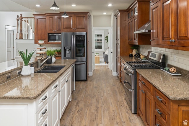 1697 S 3200 W, Logan, UT 84321 - kitchen with stainless steel appliances, under cabinet range hood, a sink, light wood-type flooring, and backsplash