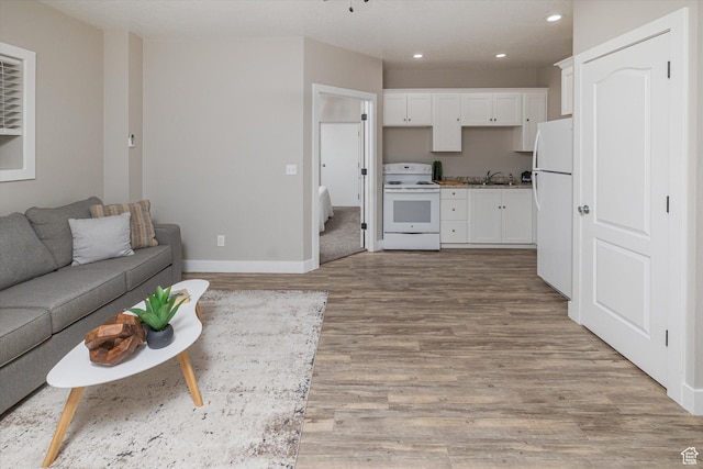 1697 S 3200 W, Logan, UT 84321 - kitchen with white appliances, open floor plan, a sink, white cabinets, and light wood-type flooring