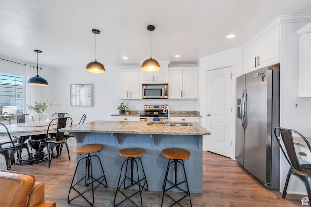 187 E 560 N, Salem, UT 84653 - kitchen featuring stainless steel appliances, a sink, white cabinetry, wood finished floors, and backsplash