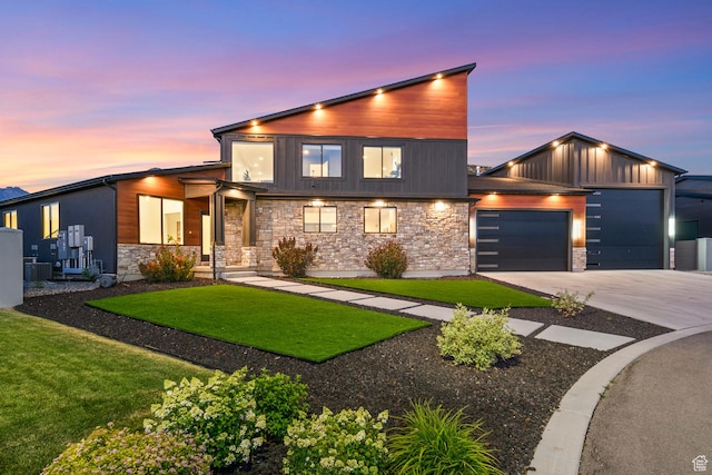 12719 S Outlaw Pl E, Draper, UT 84020 - contemporary home with driveway, an attached garage, stone siding, a yard, and board and batten siding