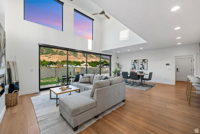 12719 S Outlaw Pl E, Draper, UT 84020 - living area featuring a towering ceiling, ceiling fan, baseboards, light wood-style flooring, and recessed lighting