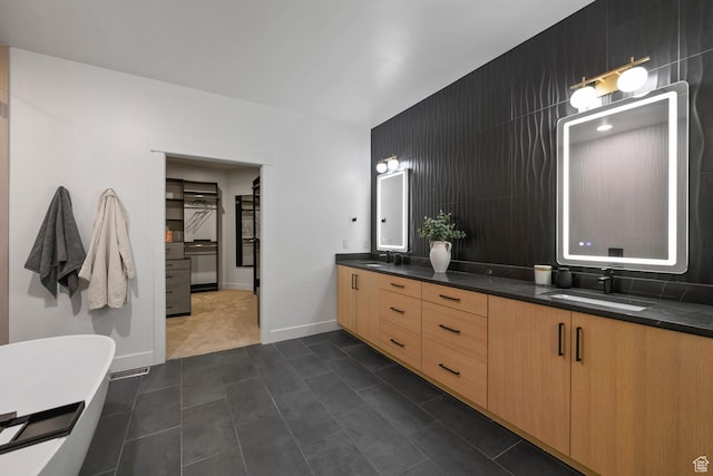 12719 S Outlaw Pl E, Draper, UT 84020 - full bathroom featuring double vanity, a freestanding tub, baseboards, and backsplash