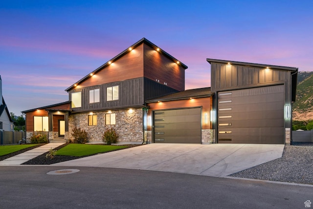 12719 S Outlaw Pl E, Draper, UT 84020 - modern home with stone siding, an attached garage, concrete driveway, and board and batten siding