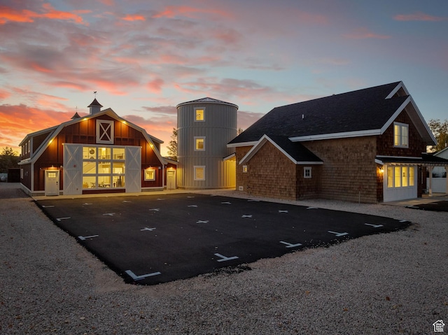 300 S 100th St W, Garden City, UT 84028 - back of house at dusk with a barn, uncovered parking, an outdoor structure, and roof with shingles