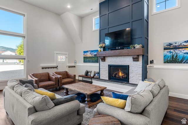 300 S 100th St W, Garden City, UT 84028 - living area with a towering ceiling, a stone fireplace, dark wood-type flooring, and baseboards