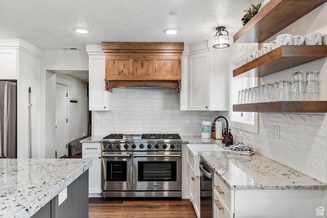 300 S 100th St W, Garden City, UT 84028 - kitchen with stainless steel appliances, open shelves, white cabinets, light stone counters, and tasteful backsplash