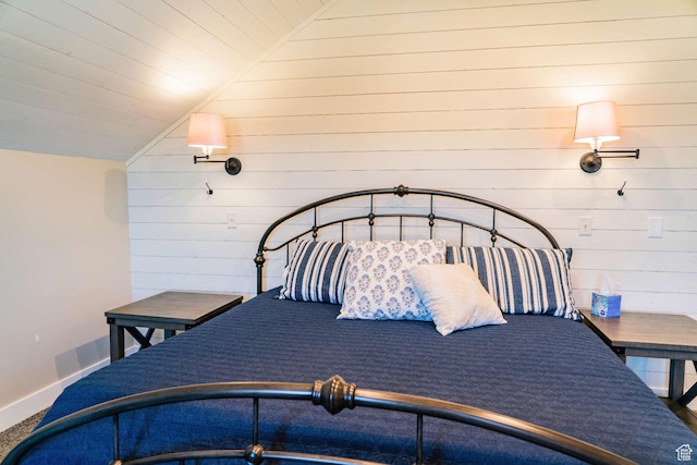 300 S 100th St W, Garden City, UT 84028 - carpeted bedroom featuring vaulted ceiling, wood walls, and baseboards