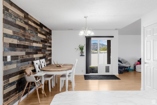 4155 S 3450 W, West Haven, UT 84401 - dining room featuring wooden walls, wood finished floors, a chandelier, an accent wall, and baseboards