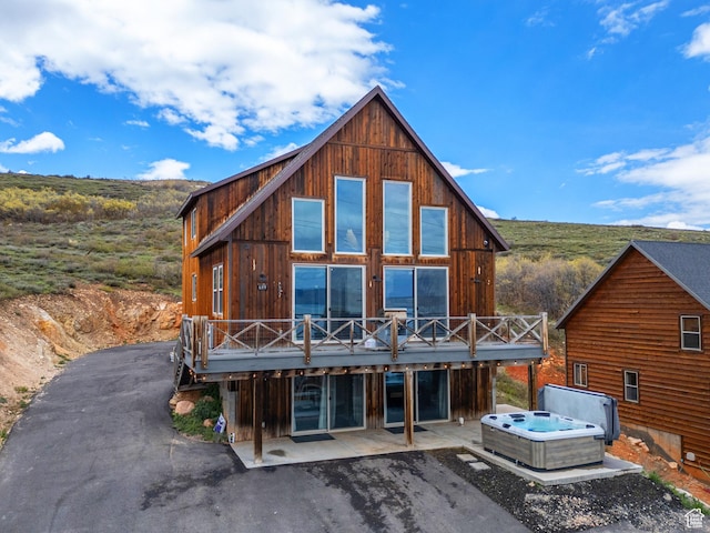 689 N Cambry Dr, Garden City, UT 84028 - back of house featuring a hot tub, a deck, a patio area, and driveway