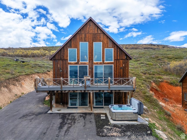 689 N Cambry Dr, Garden City, UT 84028 - back of property with a wooden deck, a patio, and a hot tub