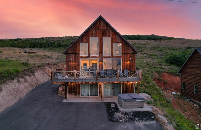 689 N Cambry Dr, Garden City, UT 84028 - back of property at dusk featuring a wooden deck and a patio area