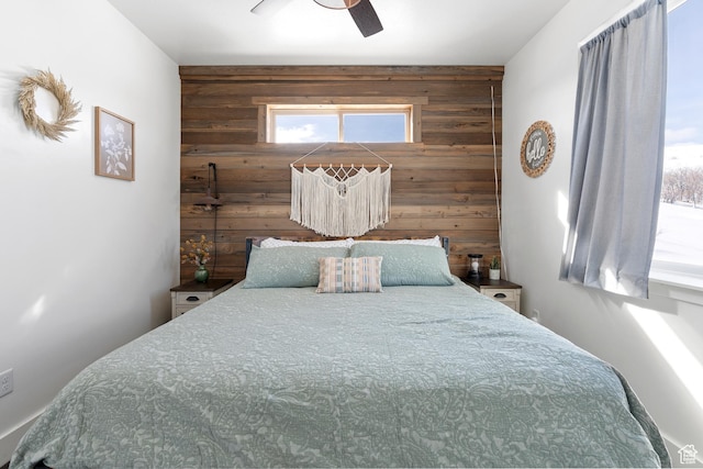 689 N Cambry Dr, Garden City, UT 84028 - bedroom with wooden walls, multiple windows, an accent wall, and ceiling fan