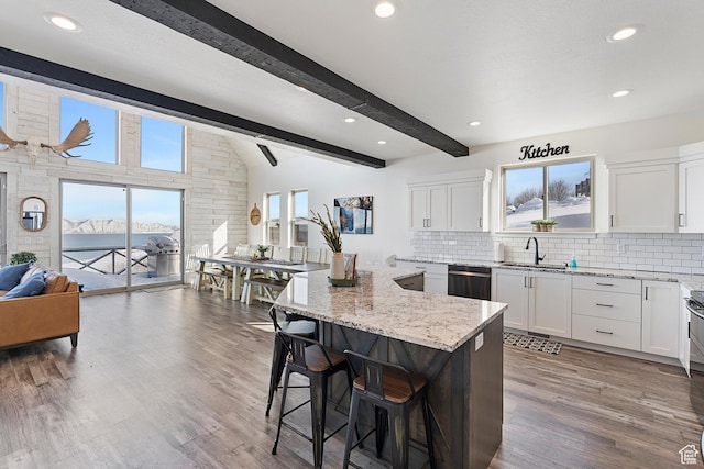 689 N Cambry Dr, Garden City, UT 84028 - kitchen with a sink, dishwasher, light stone counters, a breakfast bar, and decorative backsplash