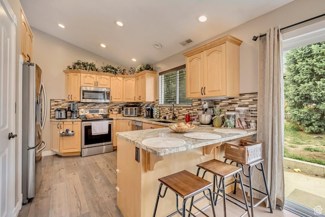 804 E 3300 N, North Ogden, UT 84414 - kitchen with stainless steel appliances, a peninsula, light brown cabinetry, a sink, and tasteful backsplash