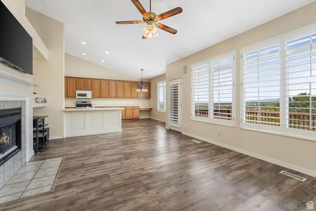 1267 E Hickenlooper Way S, Draper, UT 84020 - unfurnished living room featuring a ceiling fan, a tiled fireplace, vaulted ceiling, dark wood-style flooring, and baseboards
