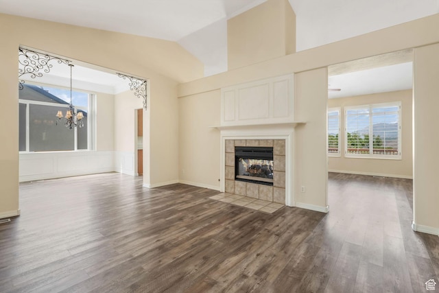 1267 E Hickenlooper Way S, Draper, UT 84020 - unfurnished living room with a chandelier, dark wood-style floors, vaulted ceiling, a tiled fireplace, and baseboards